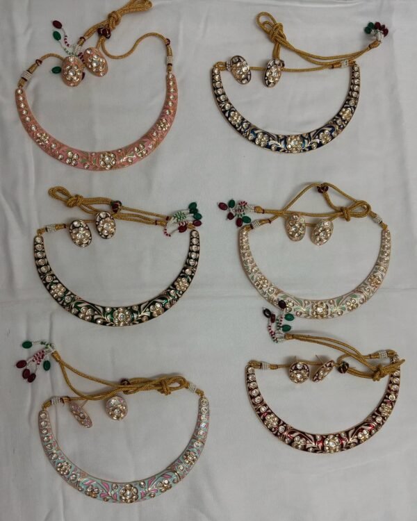 This image shows a collection of **Jadau Meenakari Hansli necklaces**, featuring intricate designs with colorful enamel work and possibly embedded stones.